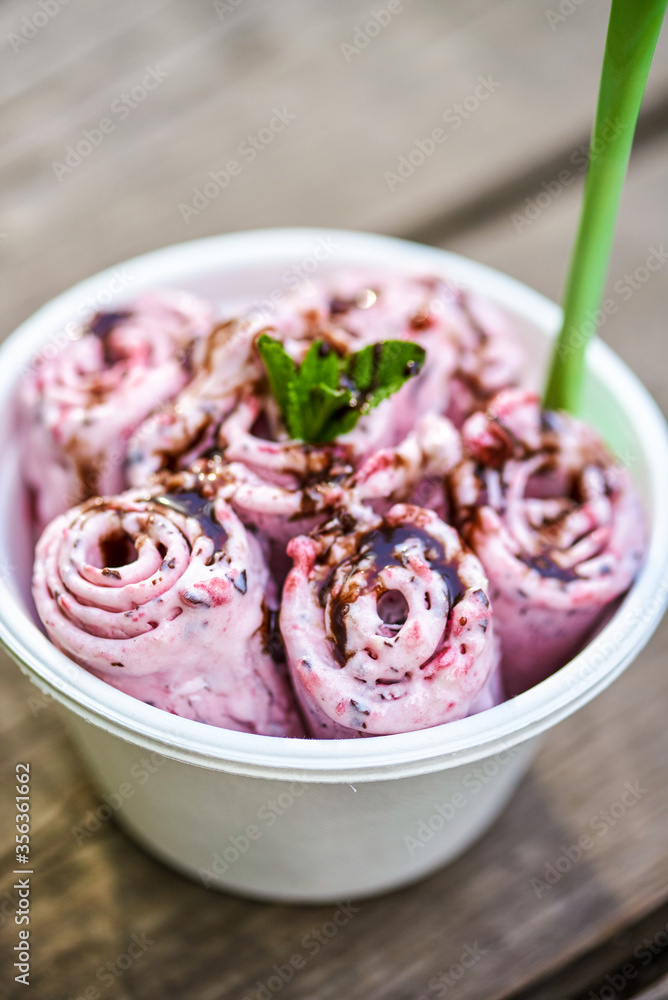 Berry ice cream with mint leaf on gray wooden background