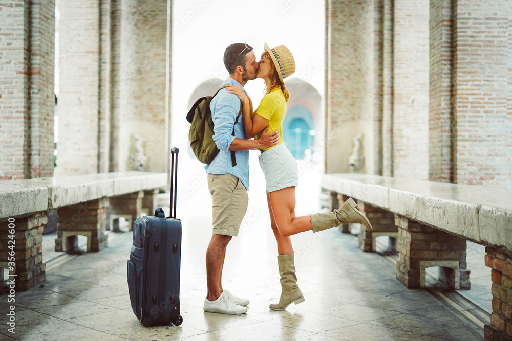 Couple at holiday having a romantic kiss on the street in the city.