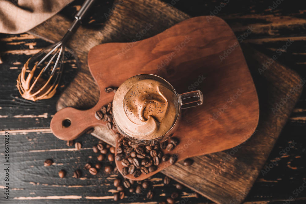 Glass cup of tasty dalgona coffee on table