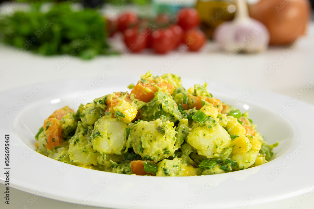 Potato mayonnaise salad with broccoli, carrot, corn and herbs