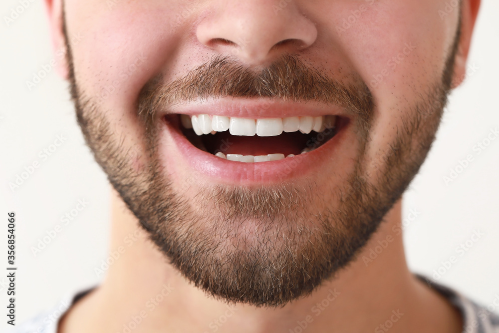 Handsome smiling young man on white background, closeup