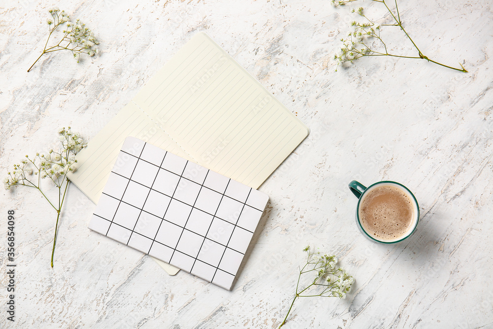 Cup of coffee with notebooks on white background