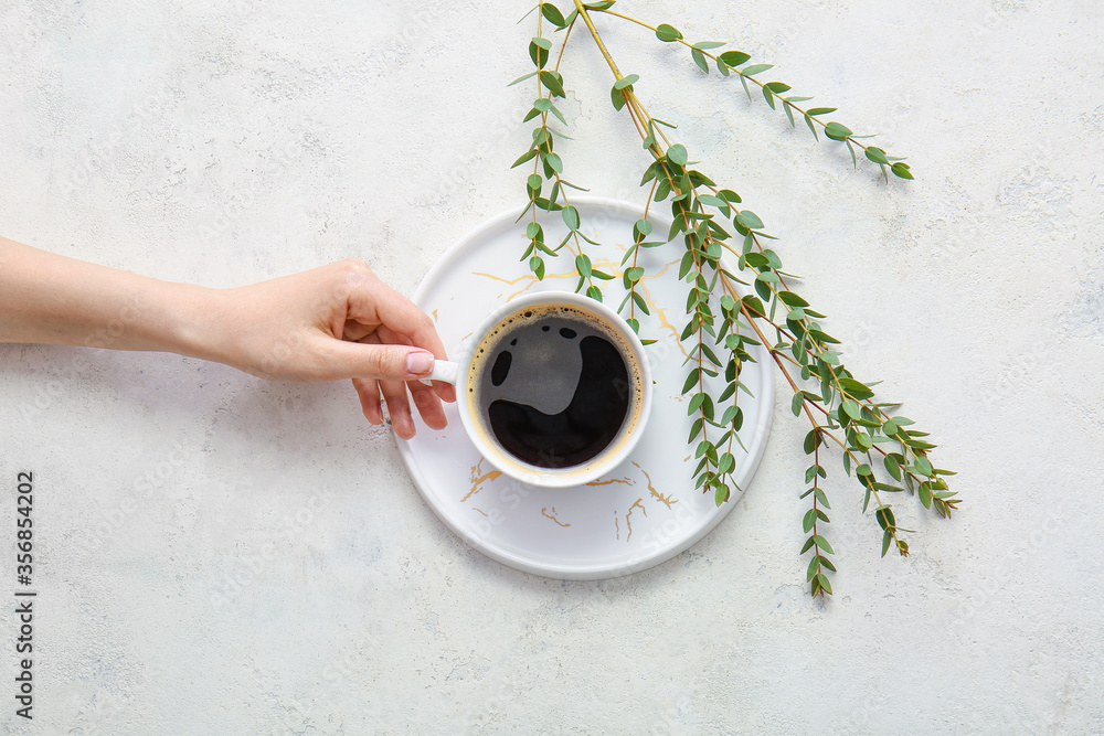 Female hand with cup of coffee on white background