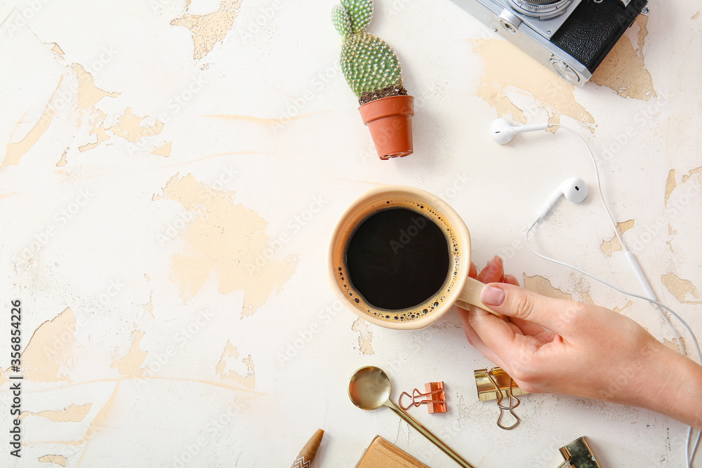 Female hand with cup of coffee on white background