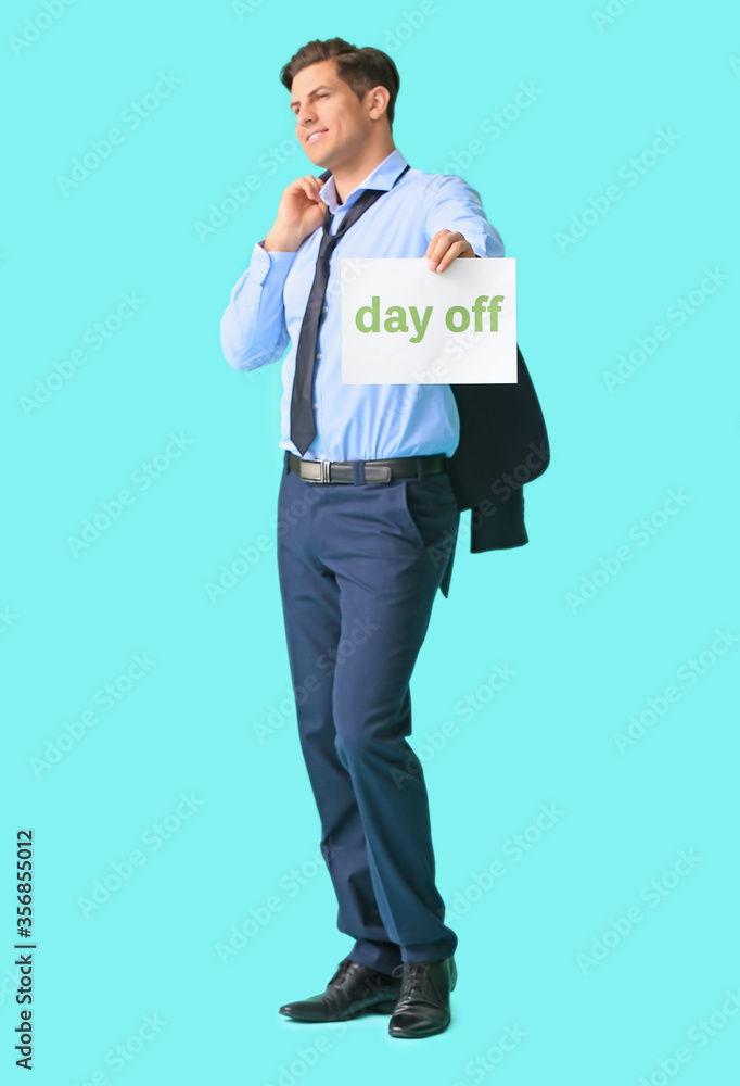 Young businessman holding paper with text DAY OFF against color background