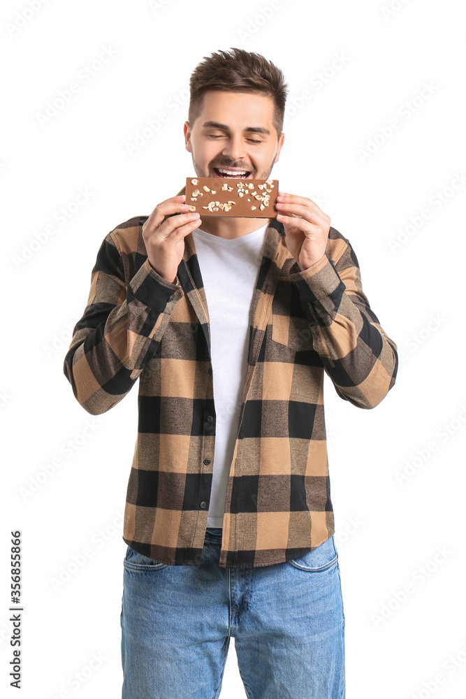 Handsome young man with tasty chocolate on white background