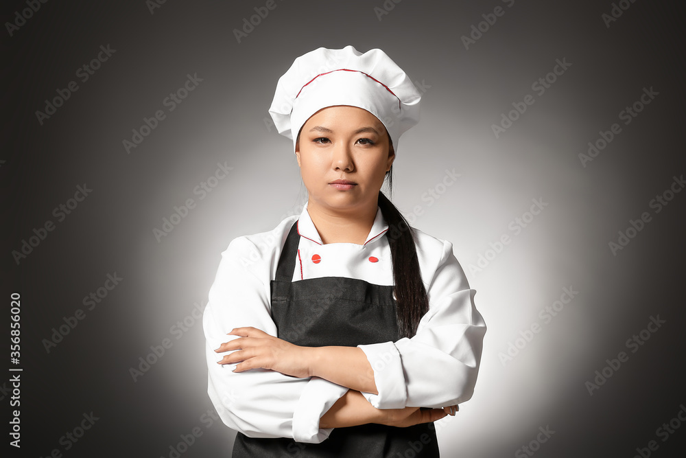 Beautiful Asian chef on dark background