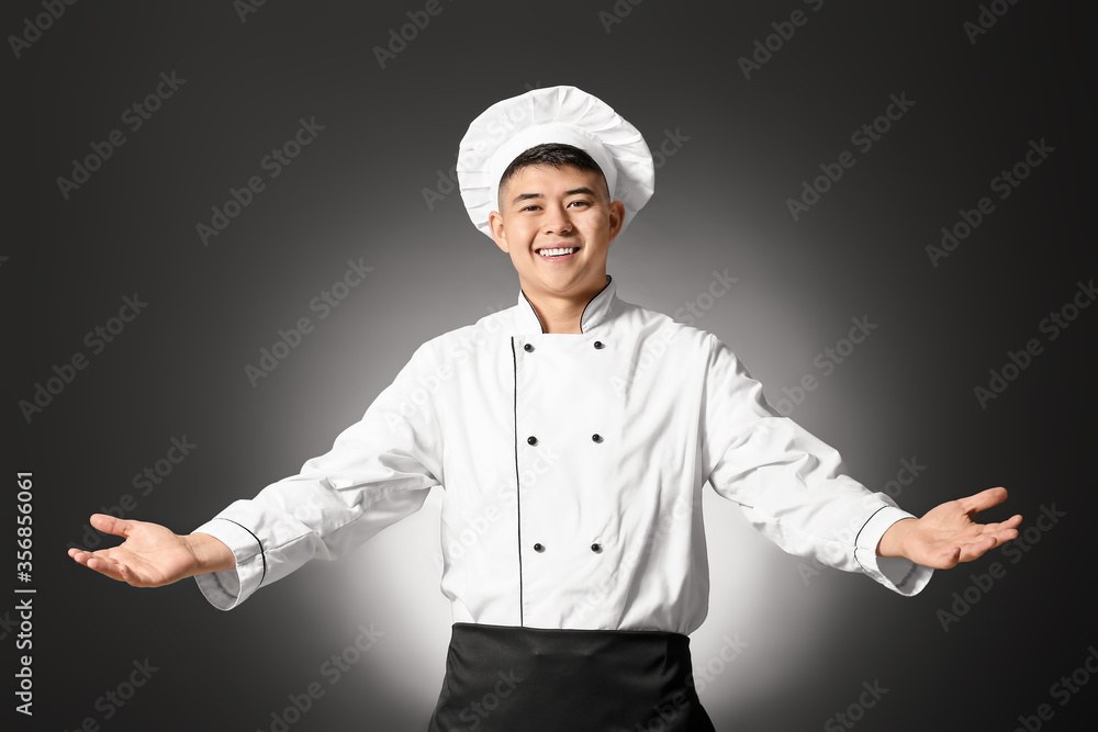 Handsome Asian chef on dark background