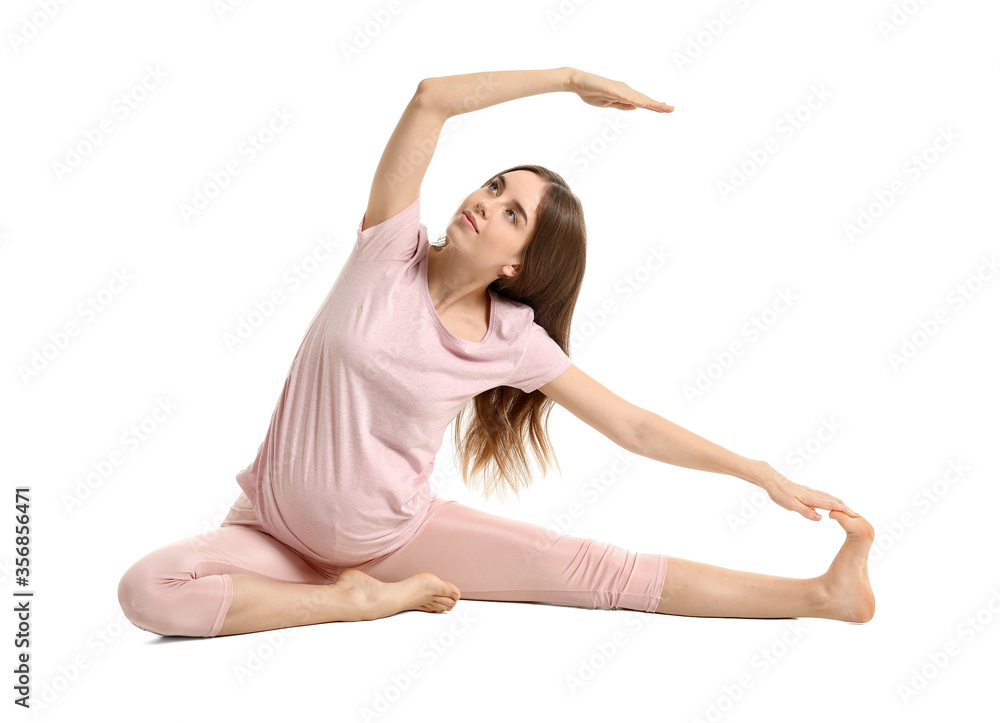 Young pregnant woman practicing yoga on white background