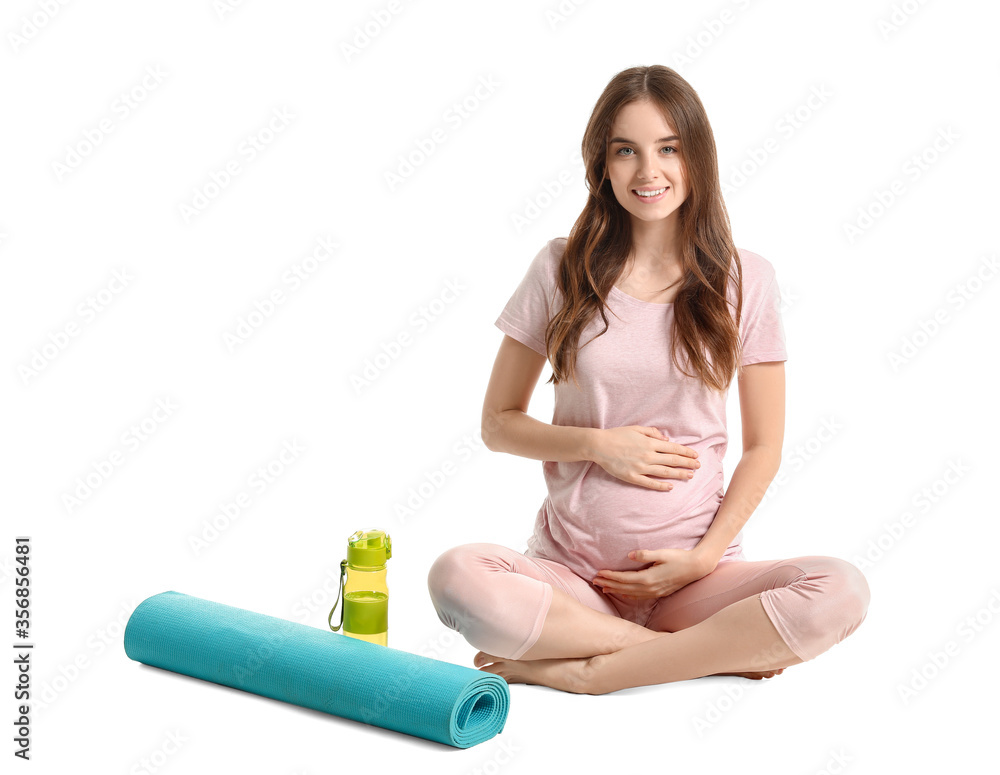 Young pregnant woman with yoga mat on white background