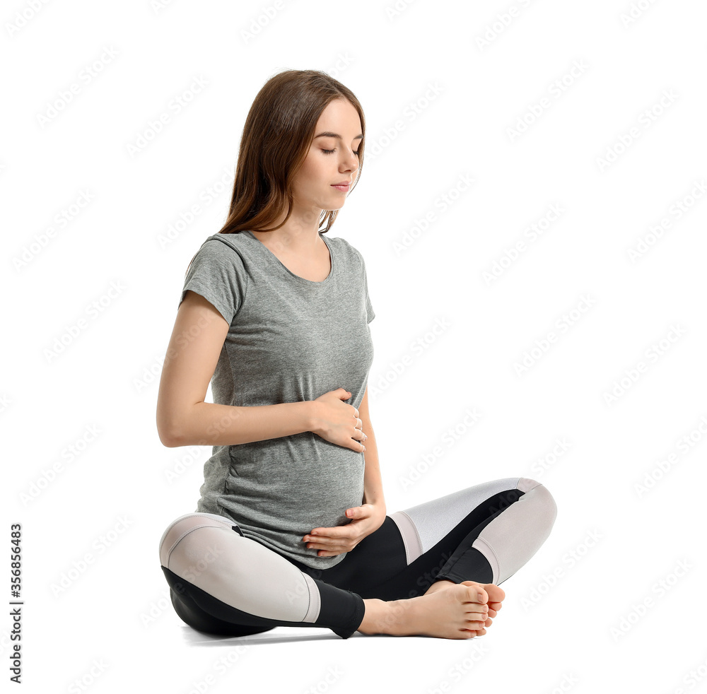 Young pregnant woman practicing yoga on white background