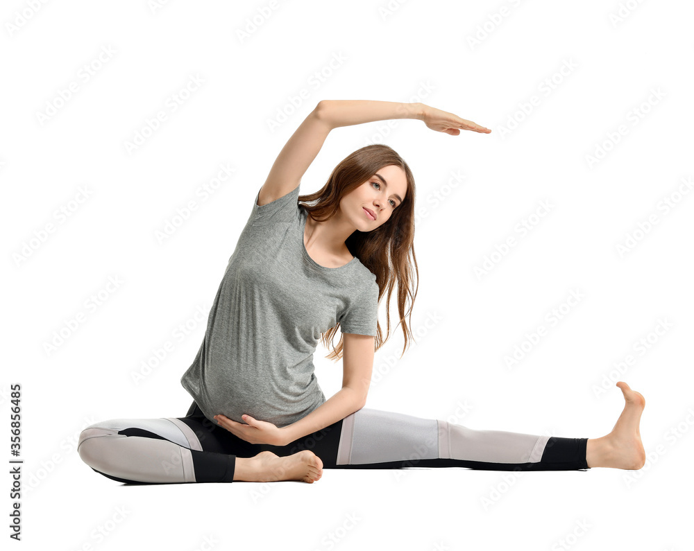 Young pregnant woman practicing yoga on white background