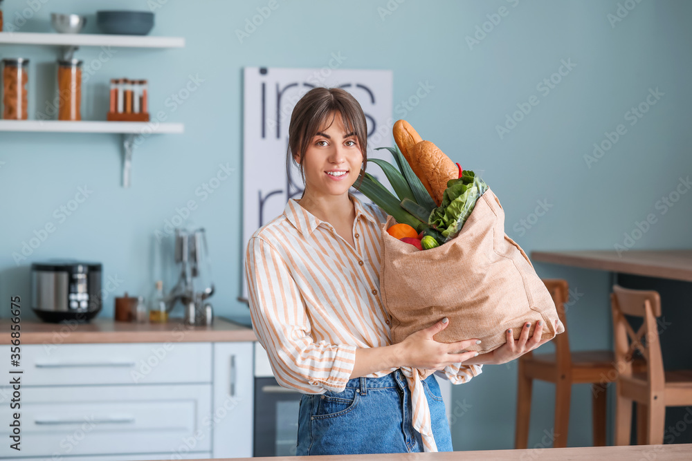 Young woman with fresh products from market at home