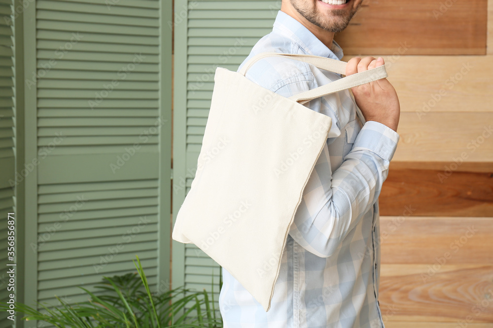 Young man with eco bag at home