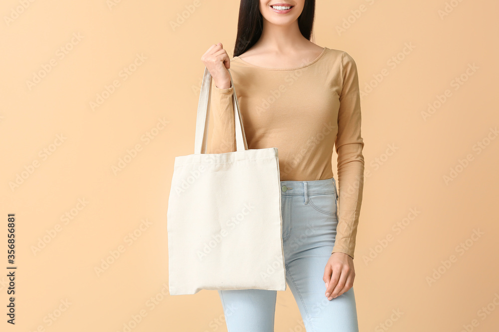 Young woman with eco bag on color background