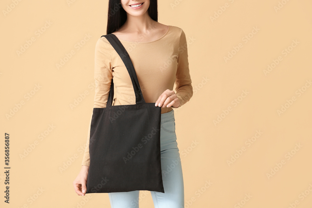 Young woman with eco bag on color background