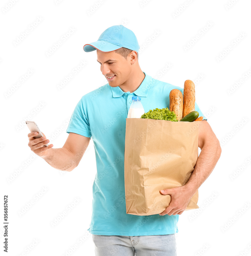 Delivery man with food in bag and mobile phone on white background