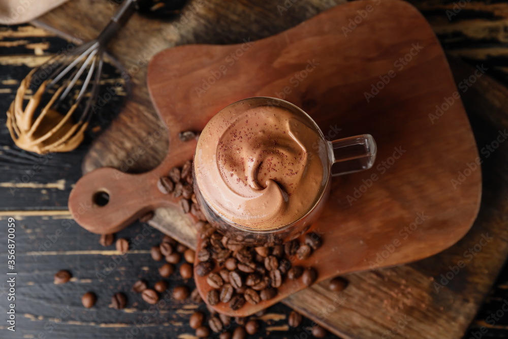 Glass cup of tasty dalgona coffee on table