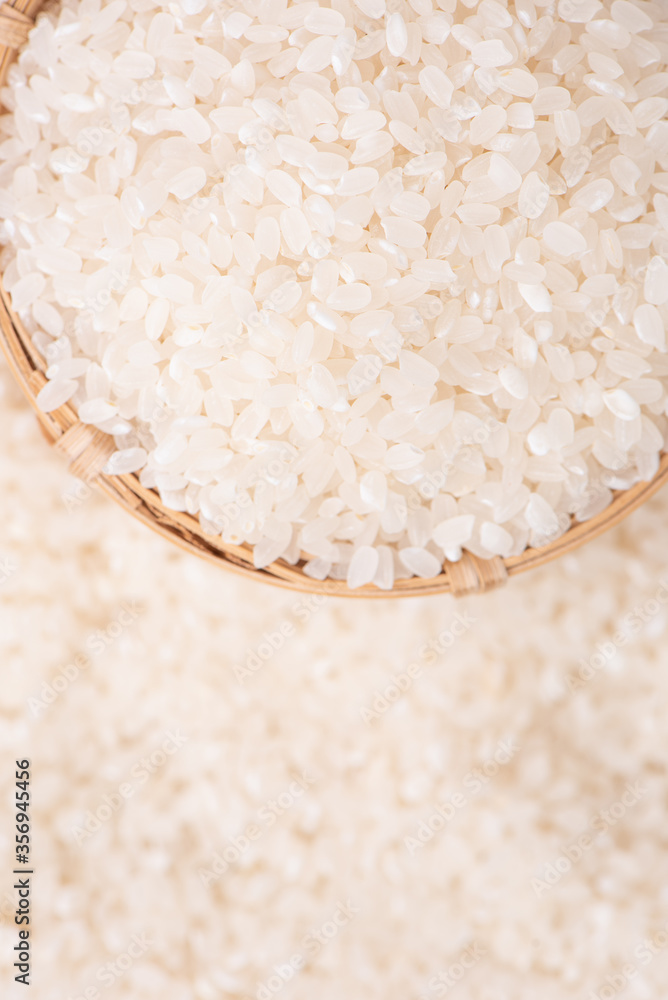 Raw rice in a bowl and full frame in the white background table, top view overhead shot, close up