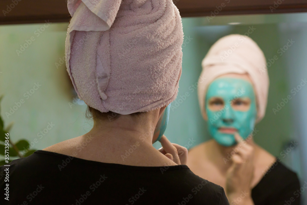 Woman applying a cosmetic mask