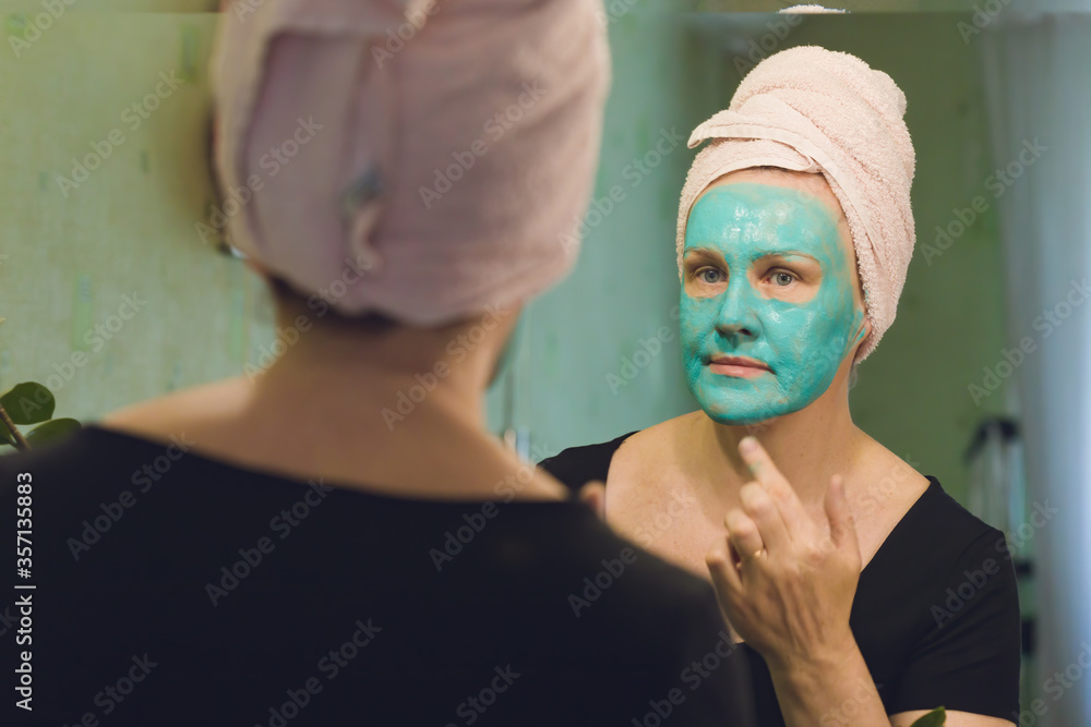 Woman applying a cosmetic mask