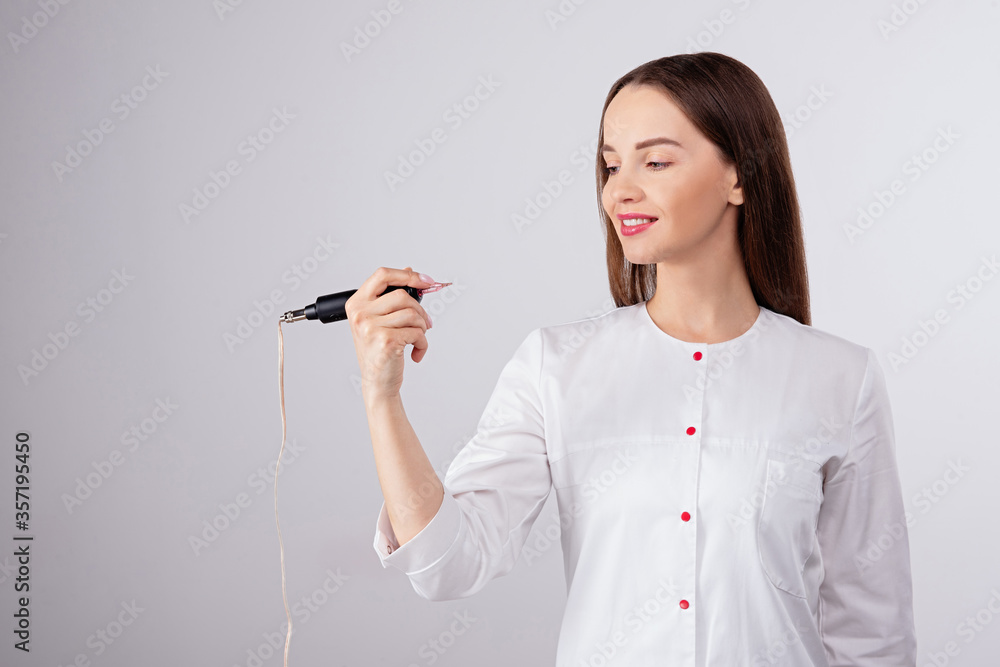 master holds microblading tool in his hands, looks at  tool for permanent makeup of eyebrows and lip