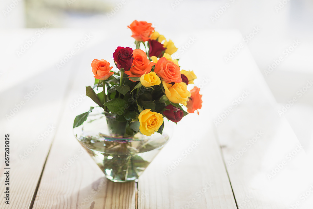 Close up of multicolor roses in vase on table