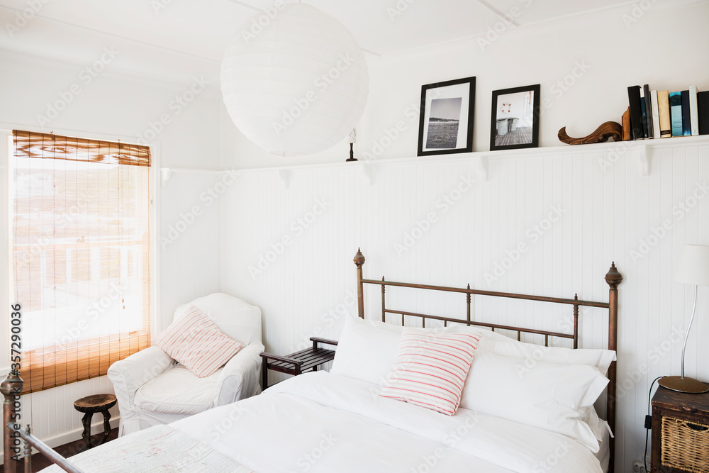 Shelf above bed in white bedroom