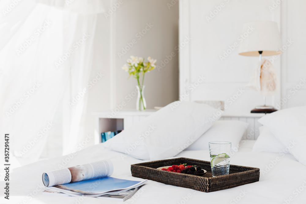 Breakfast tray and magazine on bed