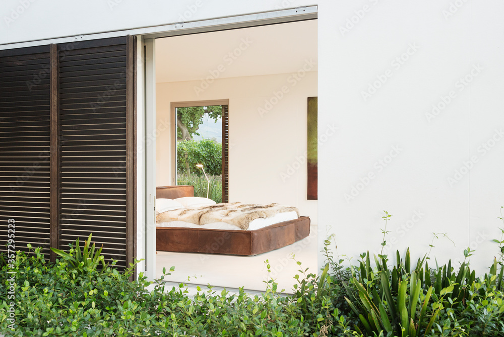 Wood shutters and sliding door to modern bedroom