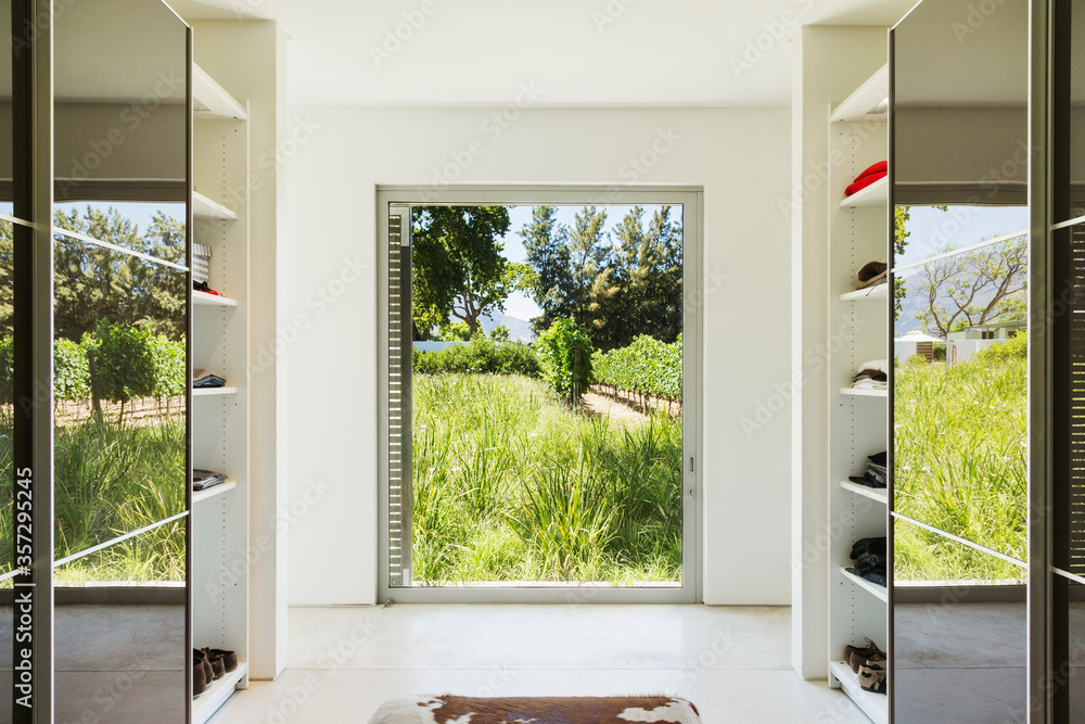 Mirrored closets framing window with view of vineyards