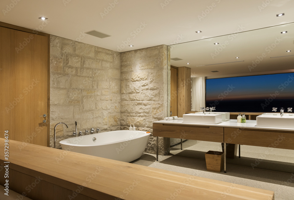 Modern bathroom with soaking tub at night