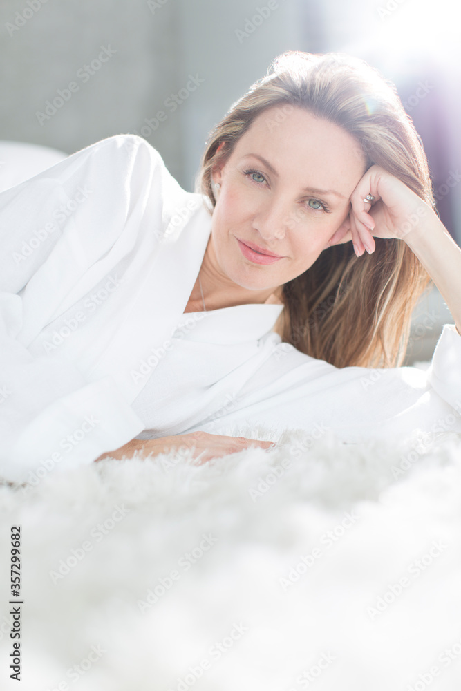 Woman in bathrobe laying on bed