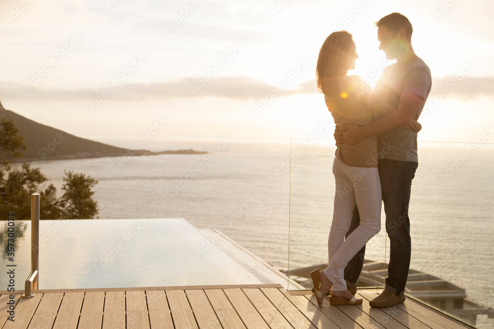 Couple on wooden deck overlooking ocean