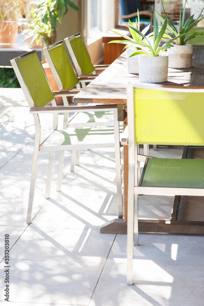 Chairs and table with potted plants on patio