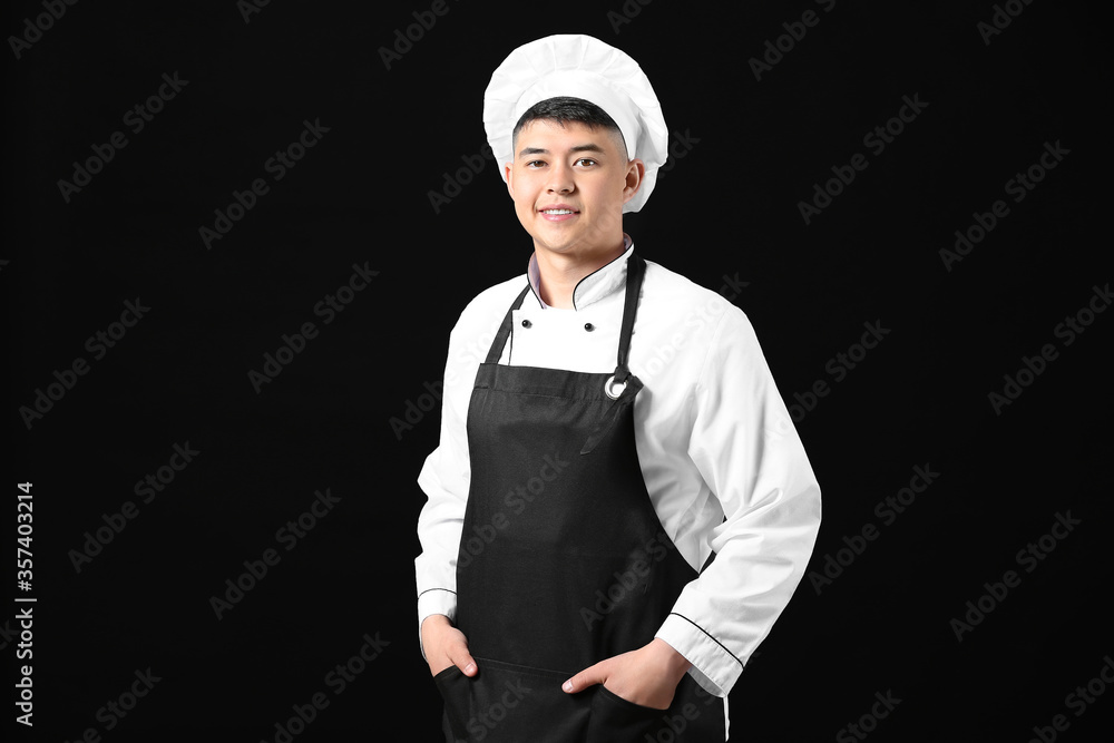 Handsome Asian chef on dark background