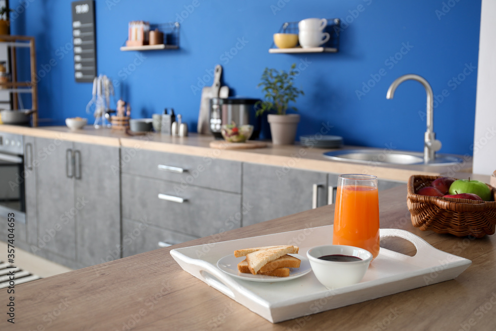 Tray with tasty breakfast in modern kitchen