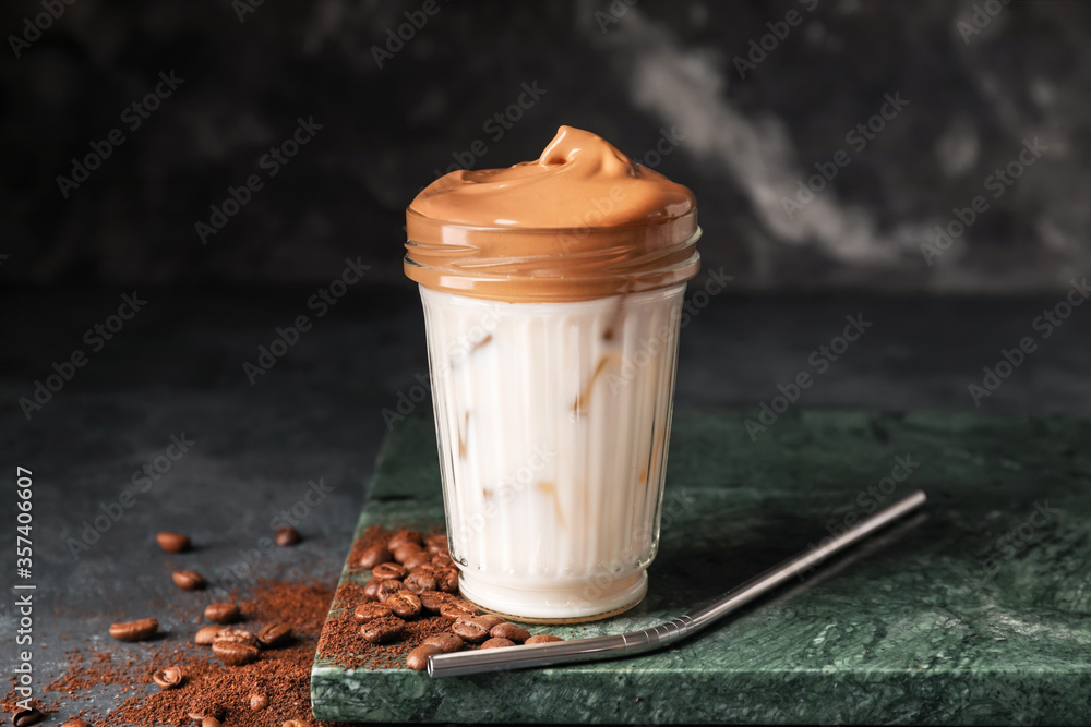 Glass of tasty dalgona coffee on dark background