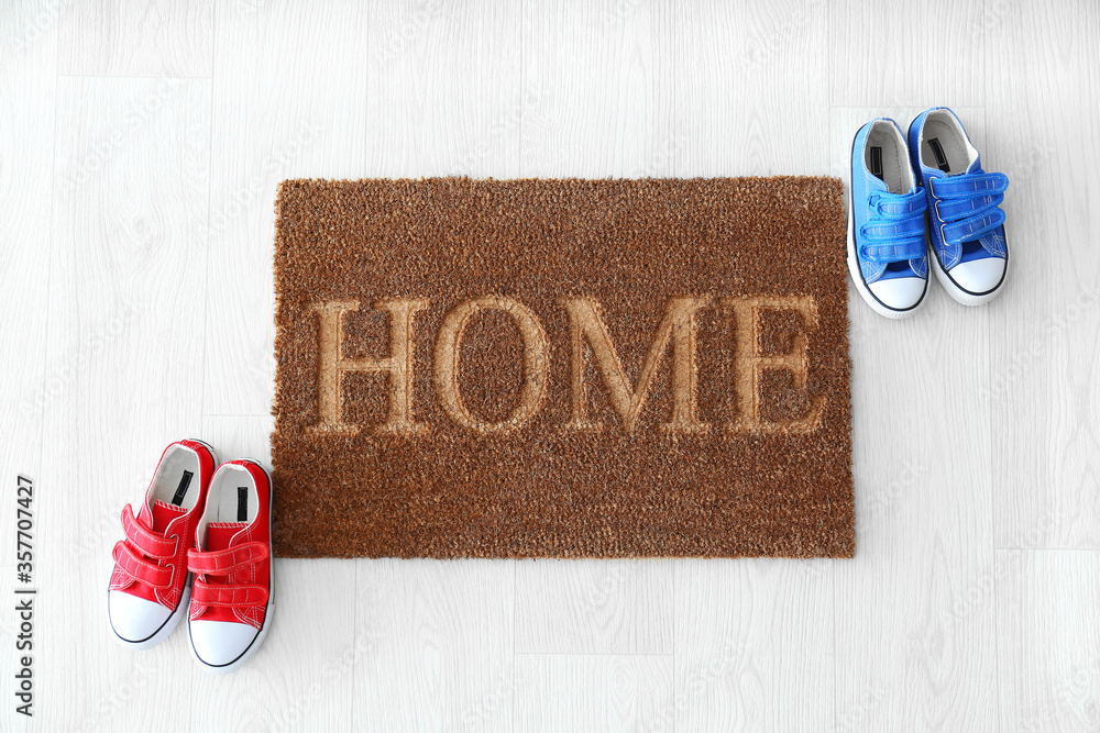 Door mat with shoes on wooden floor