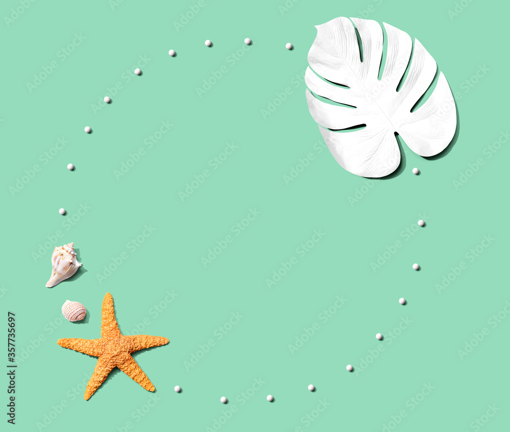 Summer concept with starfish and a painted tropical leaf - flat lay