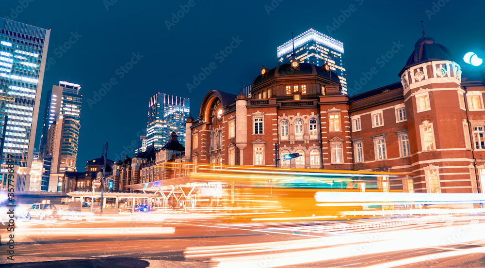 Motion blurred people crossing the intersection in front of Tokyo station at night