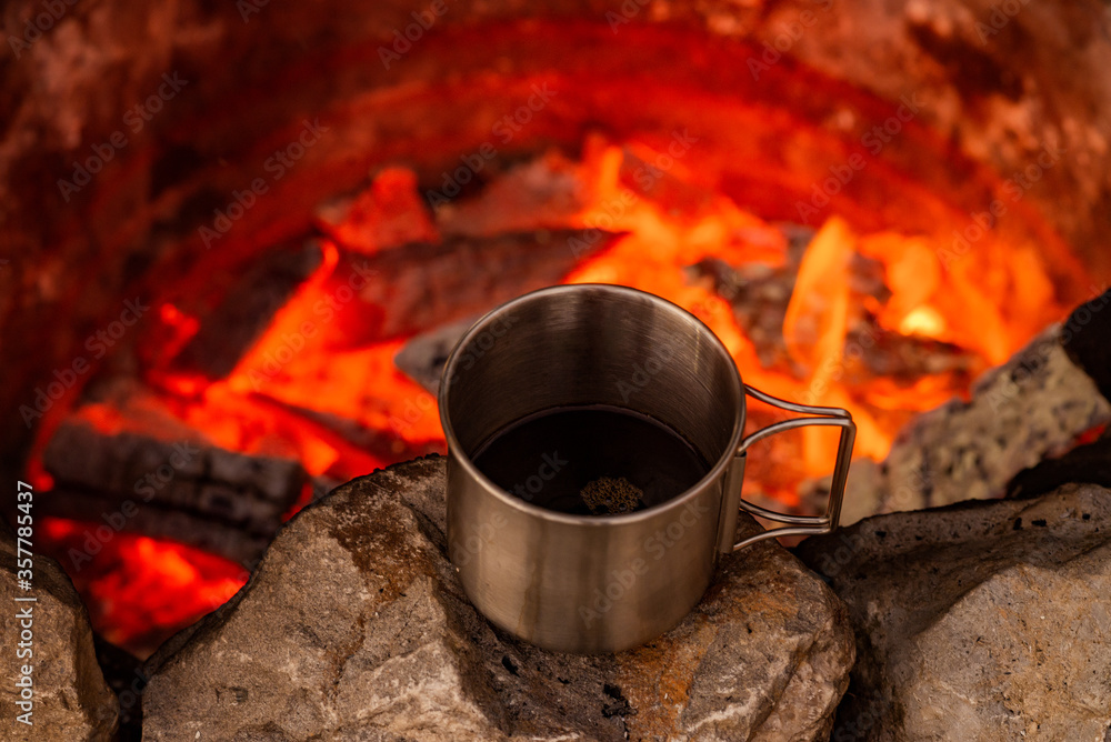 Cooking black coffee on a campfire.