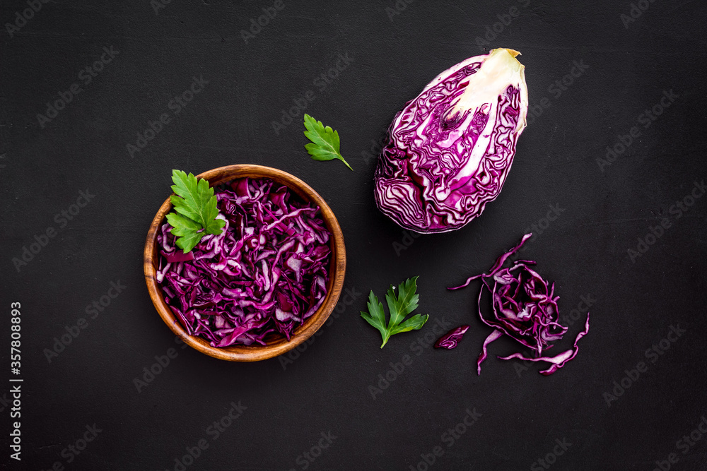 Red cabbage - cut head and sliced - on black kitchen table top view