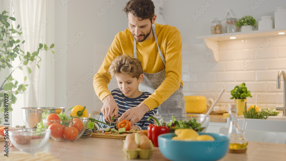 In the Kitchen: Father and Cute Little Son Cooking Together Healthy Dinner. Dad Teaches Little Boy H