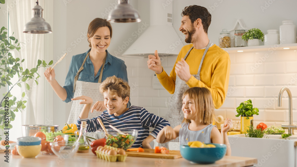 In Kitchen: Family of Four Cooking Together Healthy Dinner, Fool Around and Dance. Mother, Father, L