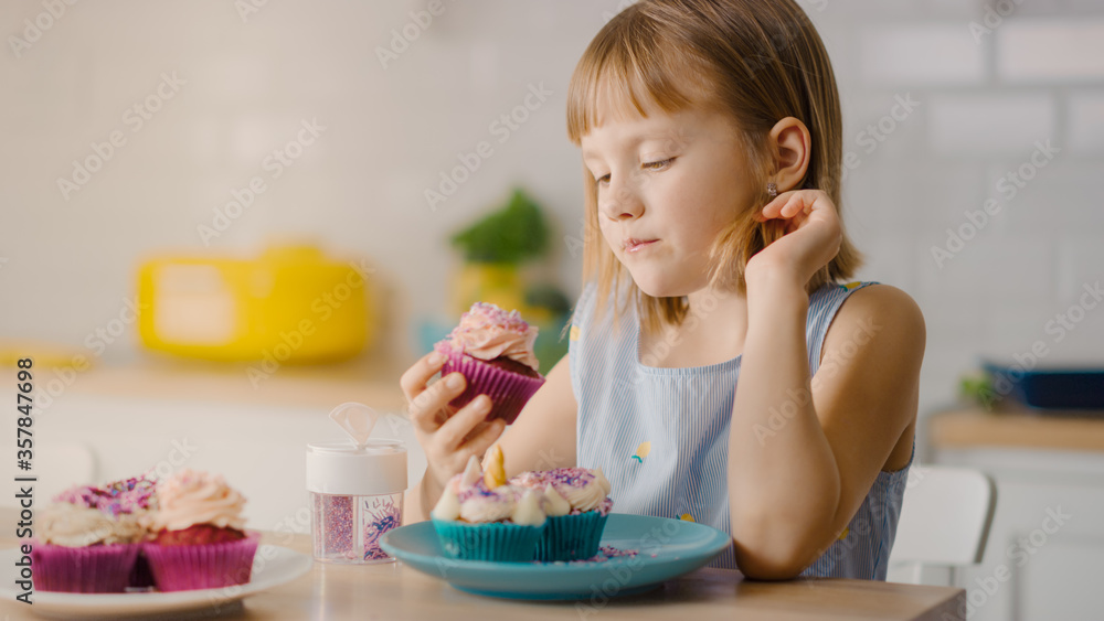 In the Kitchen: Adorable Little Girl Eats Creamy Cupcake with Frosting and Sprinkled Funfetti. Cute 