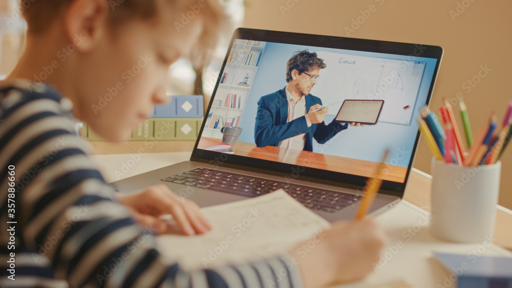 Smart Little Boy Uses Laptop for Video Call with His Teacher. Screen Shows Online Lecture with Teach