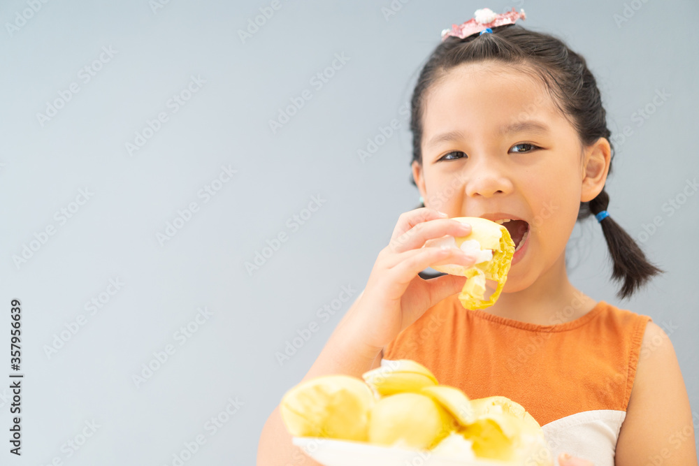 5 years old girl.Little asian thai kid girl eating durian fruit at home.She make every happy and yum