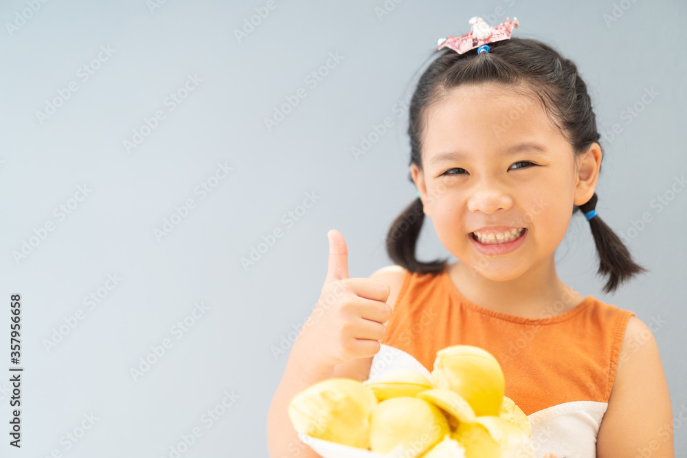 5 years old girl.Little asian thai kid girl eating durian fruit at home.She make every happy and yum