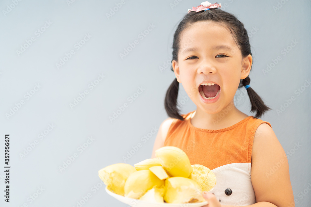 5 years old girl.Little asian thai kid girl eating durian fruit at home.She make every happy and yum